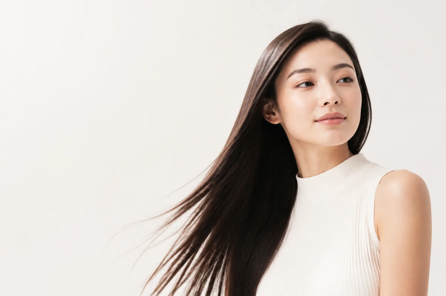 白背景でシンプルに髪を見せる、すっきりとした表情の女性のポートレート